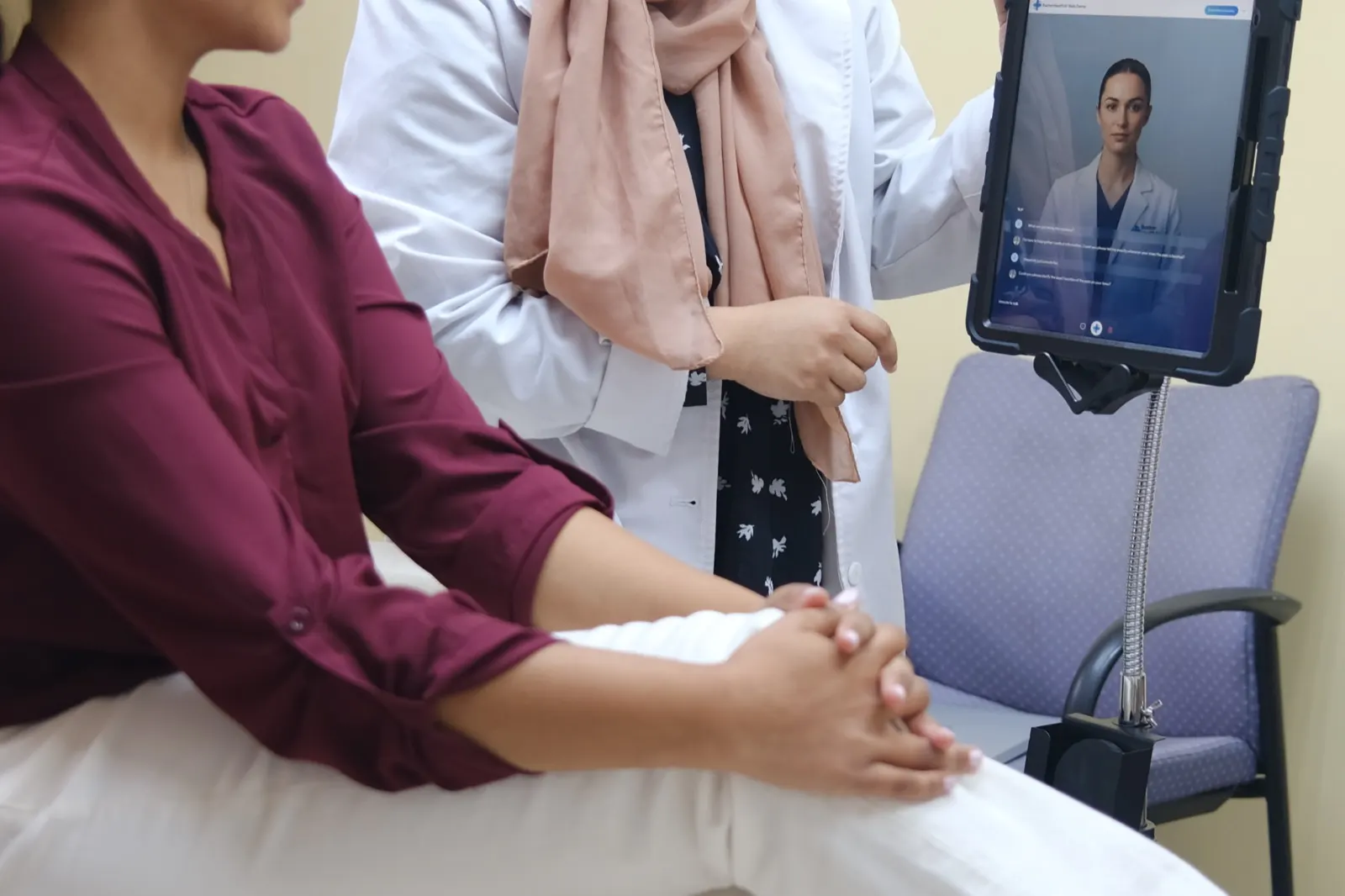 A clinician showing a patient the AI companion on a tablet at the bedside