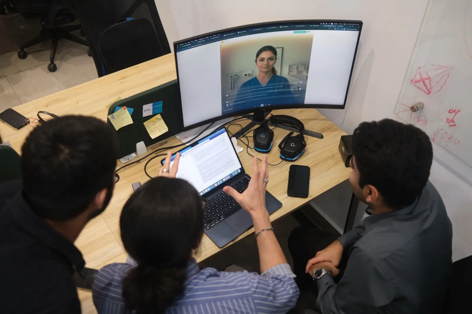 A care team reviewing a recorded encounter together on a monitor