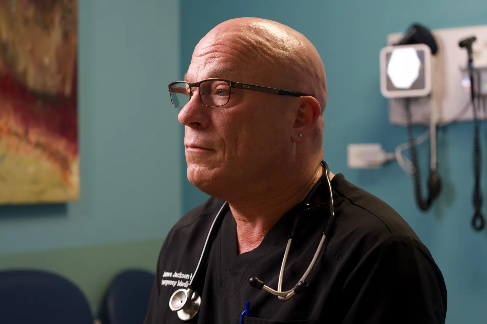 Dr. Jackson, an emergency medicine physician, in scrubs in an exam room